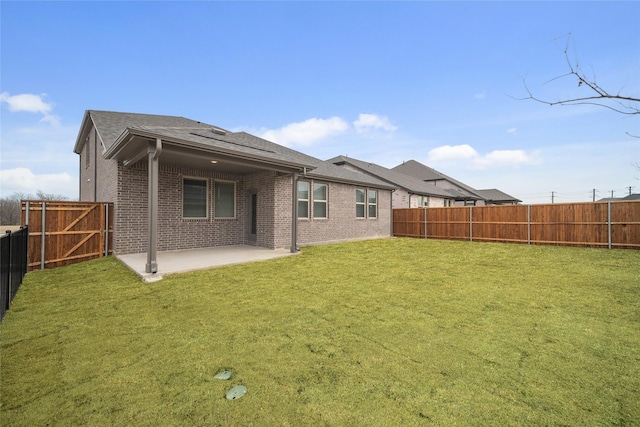 back of property with a yard and a patio area