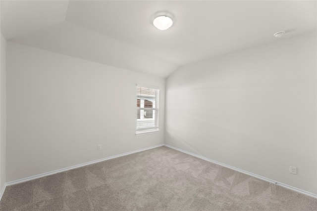 unfurnished room featuring carpet floors and vaulted ceiling