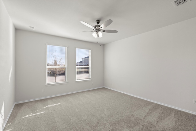 empty room featuring ceiling fan and light colored carpet