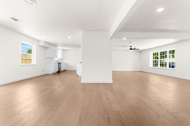 unfurnished living room with light hardwood / wood-style floors, beamed ceiling, and ceiling fan