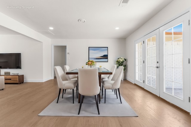 dining area with light wood-type flooring and french doors