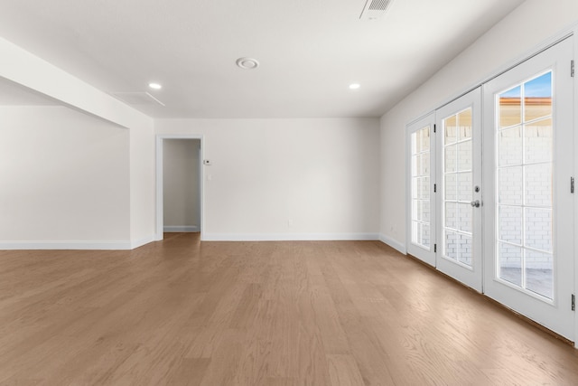 empty room featuring french doors and light hardwood / wood-style flooring