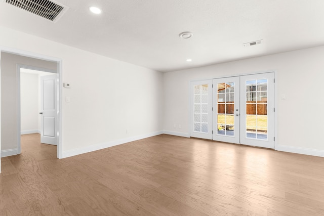 spare room with light wood-type flooring and french doors