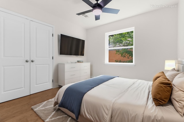 bedroom with wood-type flooring, ceiling fan, and a closet