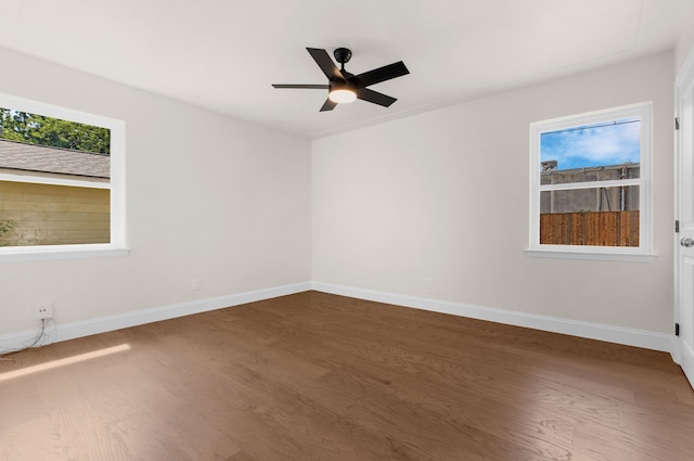 unfurnished room featuring ceiling fan, a wealth of natural light, and wood-type flooring