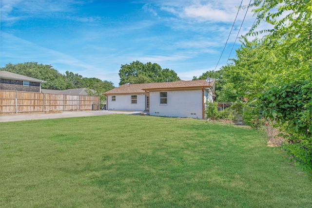 rear view of property featuring a patio area and a yard