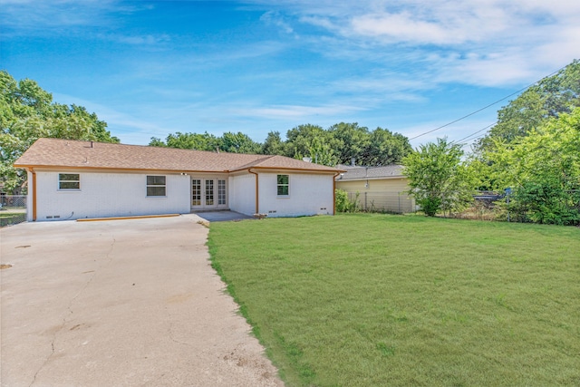 rear view of property featuring french doors and a yard