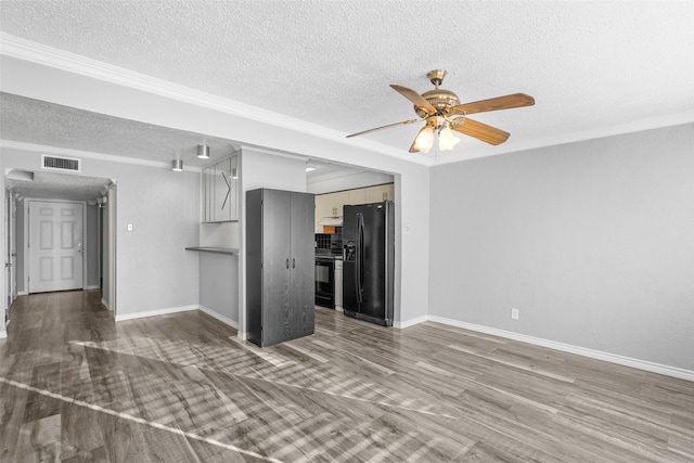 unfurnished living room featuring a textured ceiling, wood-type flooring, and crown molding