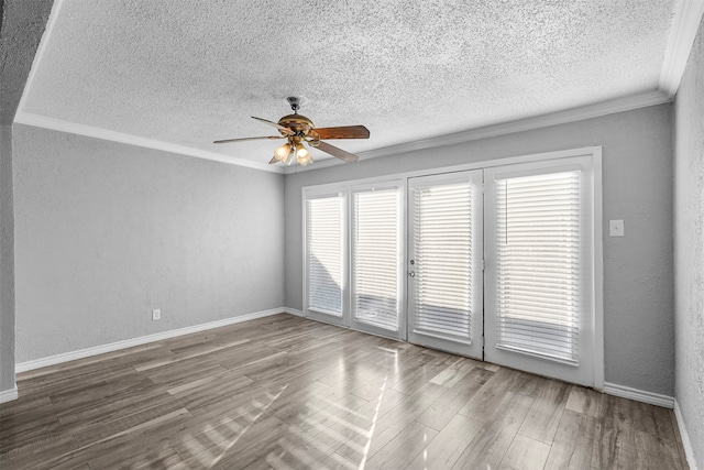 unfurnished room with a wealth of natural light, ceiling fan, hardwood / wood-style flooring, and crown molding