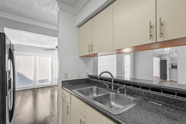 kitchen with dark hardwood / wood-style flooring, refrigerator with ice dispenser, crown molding, and cream cabinetry