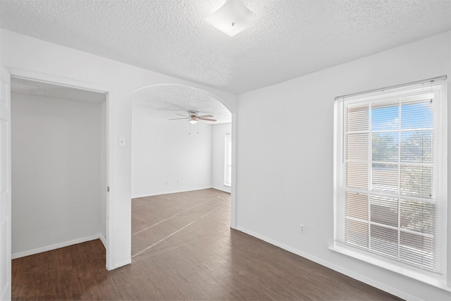 spare room with a textured ceiling, dark hardwood / wood-style floors, and ceiling fan