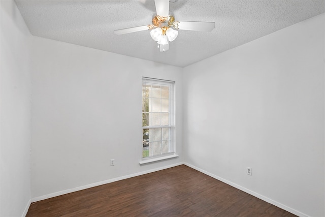 spare room featuring ceiling fan, dark wood-type flooring, and a textured ceiling