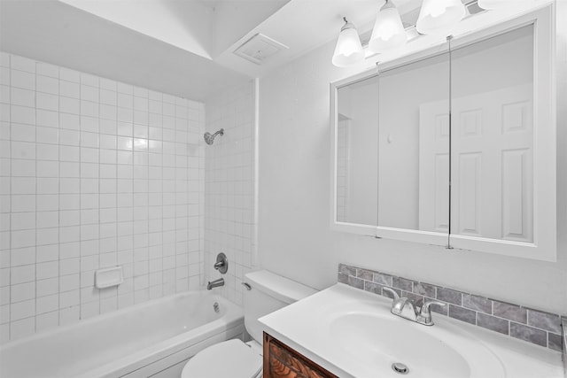 full bathroom featuring tiled shower / bath, vanity, and toilet