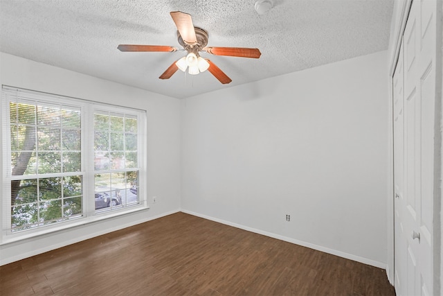 spare room with a textured ceiling, dark hardwood / wood-style floors, and ceiling fan