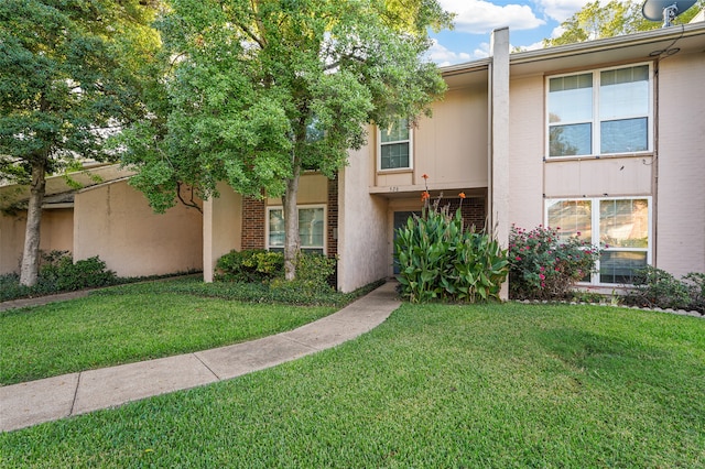 townhome / multi-family property with a front yard