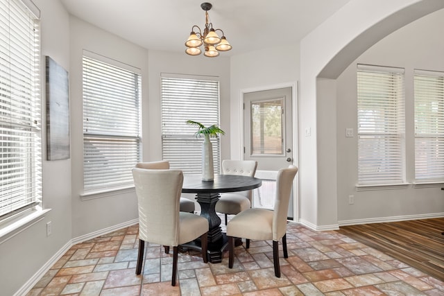 dining area featuring light hardwood / wood-style flooring, a notable chandelier, and a wealth of natural light