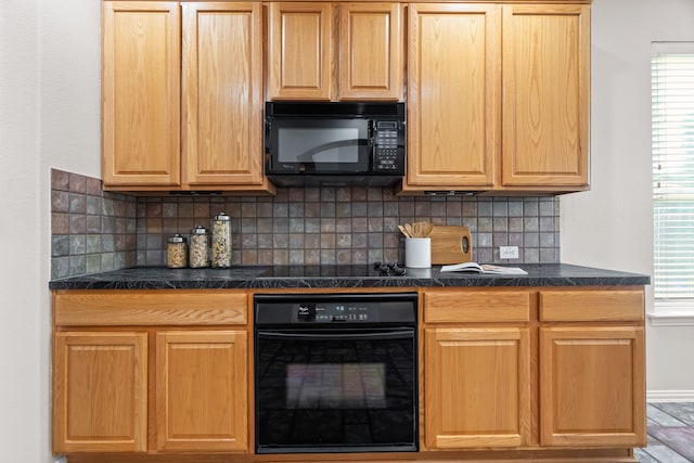 kitchen featuring black appliances, a wealth of natural light, and backsplash