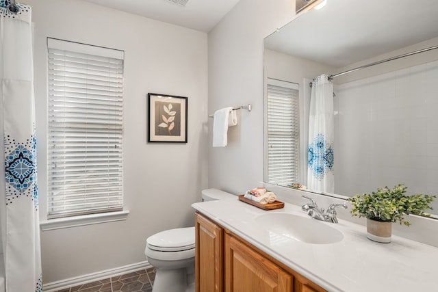 bathroom with a healthy amount of sunlight, vanity, and toilet