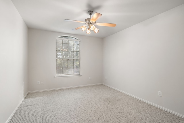 carpeted spare room featuring ceiling fan