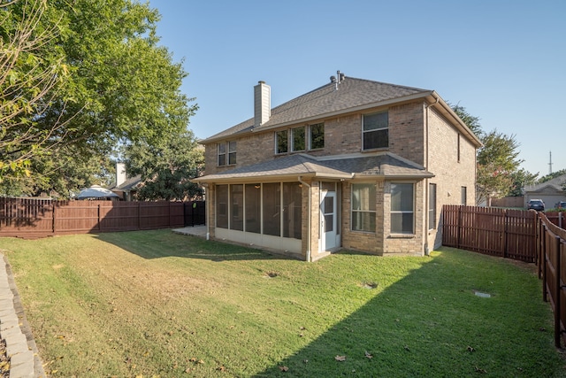 rear view of property with a sunroom and a lawn