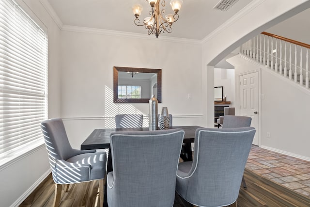 dining area with ornamental molding and a chandelier