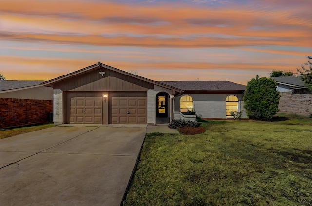 ranch-style house with a garage and a yard