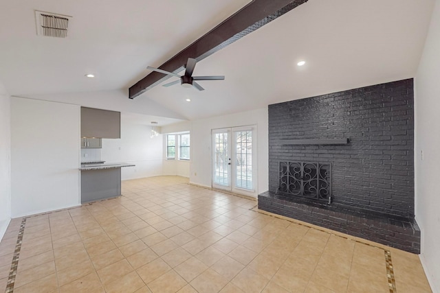 unfurnished living room with ceiling fan, french doors, vaulted ceiling with beams, a fireplace, and light tile patterned floors