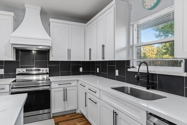 kitchen with tasteful backsplash, sink, appliances with stainless steel finishes, custom range hood, and white cabinets