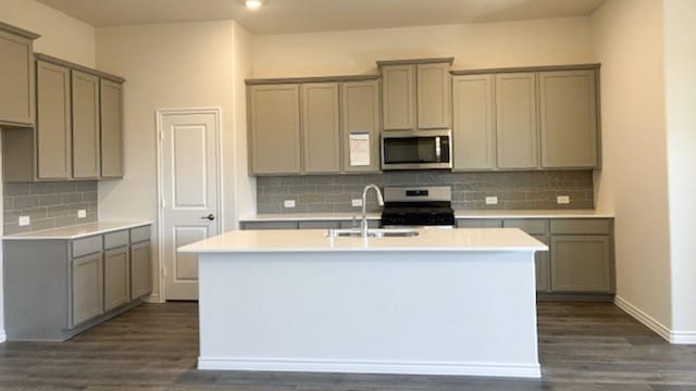 kitchen featuring a kitchen island with sink, appliances with stainless steel finishes, gray cabinets, and sink