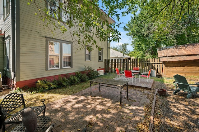 view of patio with a deck and fence