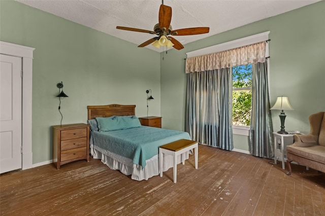 bedroom with hardwood / wood-style floors, a textured ceiling, ceiling fan, and baseboards