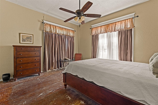 bedroom with a ceiling fan, a textured wall, and a textured ceiling