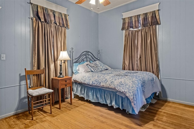 bedroom with crown molding, wood finished floors, and ceiling fan
