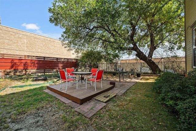 view of yard featuring a fenced backyard, a fire pit, and a wooden deck