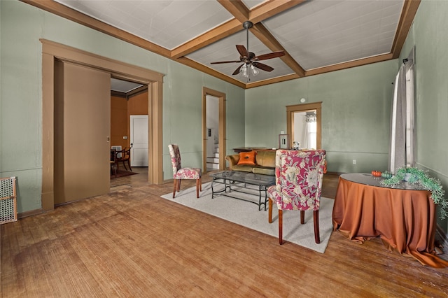 living area with beam ceiling, coffered ceiling, and ceiling fan