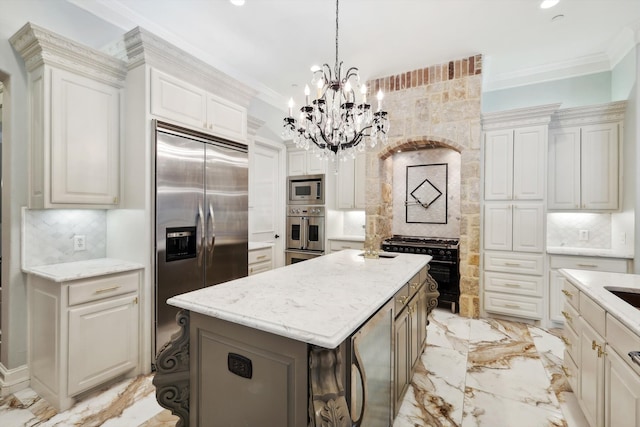 kitchen with built in appliances, a kitchen island, backsplash, and a chandelier