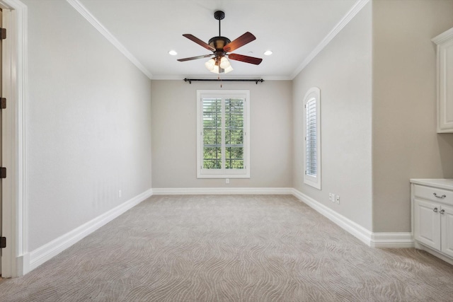 carpeted spare room with ceiling fan and ornamental molding