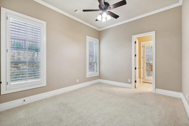 carpeted spare room featuring ceiling fan, a healthy amount of sunlight, and ornamental molding