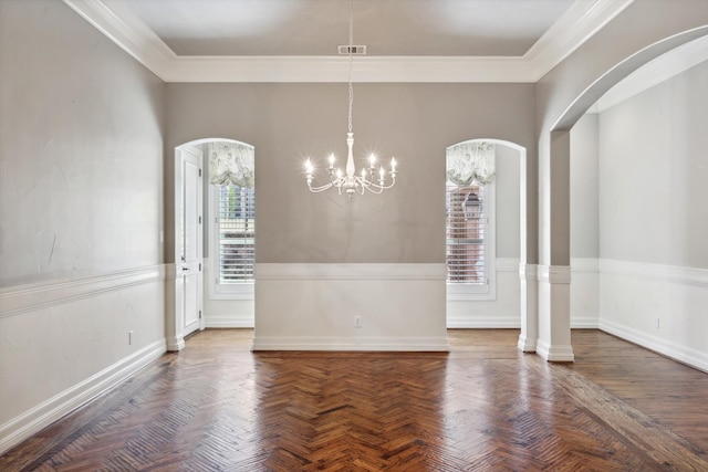 unfurnished dining area featuring dark parquet flooring, ornamental molding, and an inviting chandelier