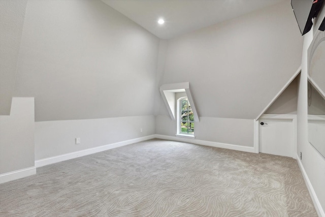 additional living space with light colored carpet and lofted ceiling