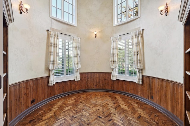 empty room featuring parquet floors and a healthy amount of sunlight