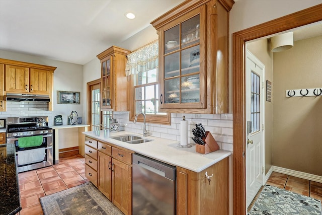 kitchen featuring decorative backsplash, stainless steel appliances, light tile patterned floors, and sink