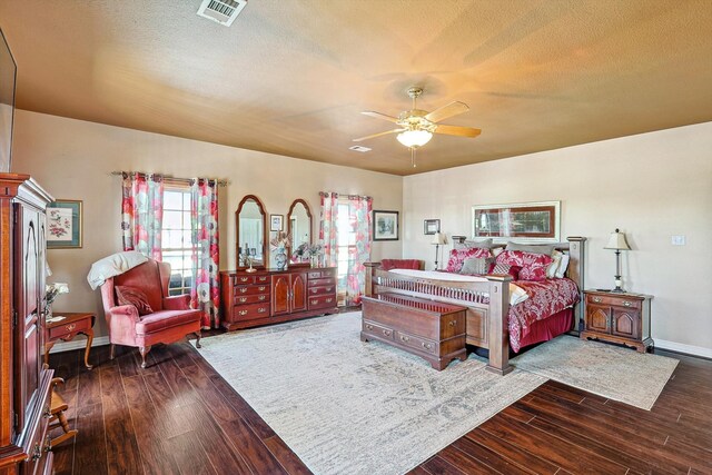 bedroom featuring ceiling fan, a textured ceiling, and dark hardwood / wood-style flooring