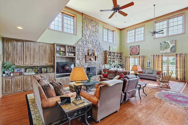 living room featuring light wood-type flooring, a fireplace, and plenty of natural light