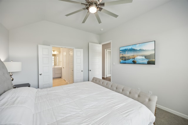 carpeted bedroom with ceiling fan, ensuite bathroom, and vaulted ceiling