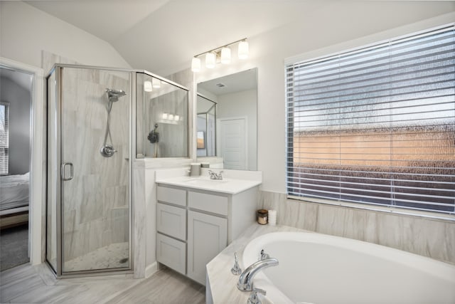 bathroom with separate shower and tub, vanity, and vaulted ceiling