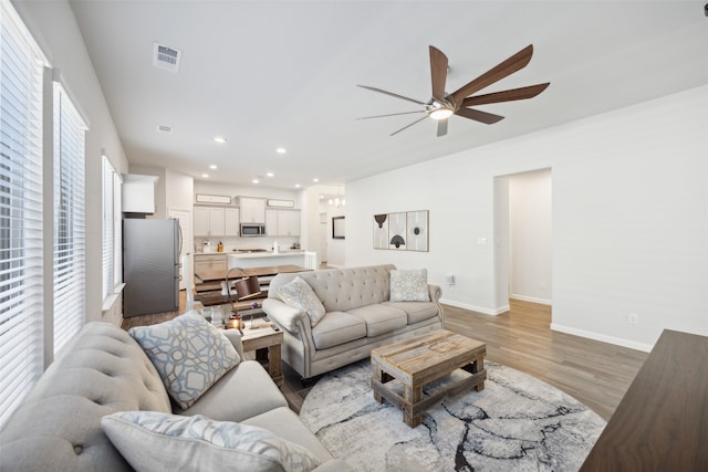 living room featuring light hardwood / wood-style flooring and ceiling fan