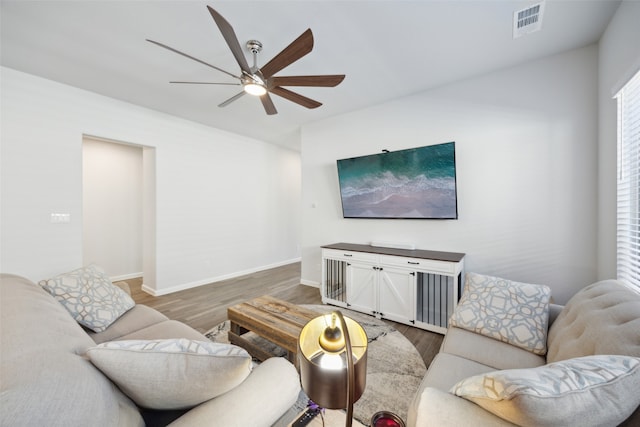 living room featuring ceiling fan and dark wood-type flooring