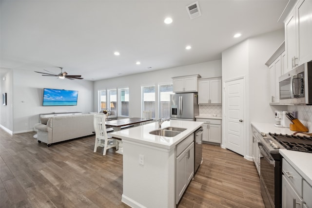 kitchen featuring an island with sink, hardwood / wood-style floors, appliances with stainless steel finishes, and sink