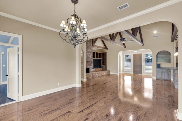 unfurnished living room with lofted ceiling with beams, ceiling fan with notable chandelier, hardwood / wood-style floors, and crown molding